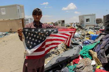 An Afghan man shows a US flag in southern Afghanistan as concerns grow over the protection of translators and others who helped US and Nato forces. EPA