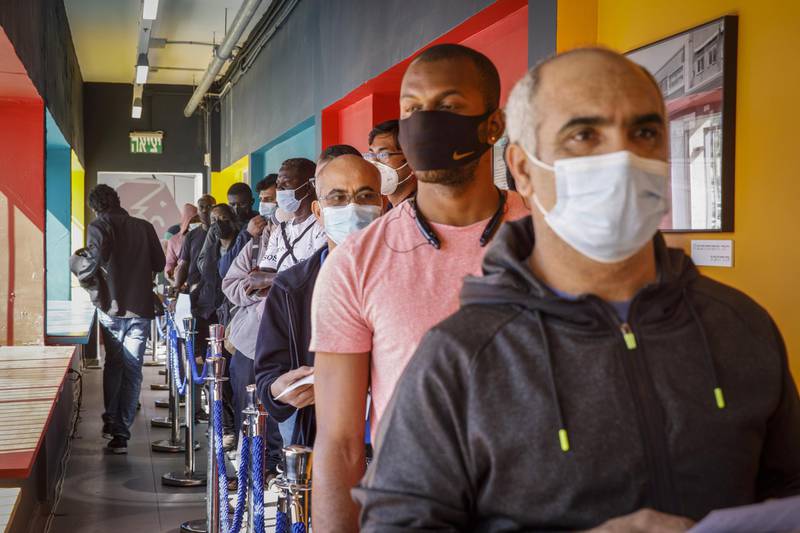 Foreign nationals queue to receive a dose of the Pfizer-BioNTech Covid-19 vaccine at a vaccination centre in Tel Aviv. Bloomberg