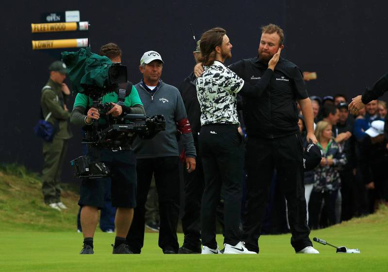 Lowry hugs Tommy Fleetwood of England on the 18th green. Getty Images