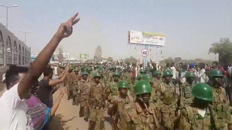 Demonstrators salute soldiers during a protest in Khartoum, Sudan April 10, 2019 in this still image taken from a video obtained from social media. TWITTER/@THAWRAGYSD/via REUTERS  ATTENTION EDITORS - THIS IMAGE HAS BEEN SUPPLIED BY A THIRD PARTY. MANDATORY CREDIT.