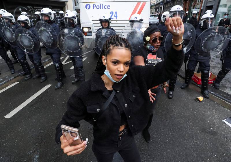 A demonstrator holds up her fist, in front of police officers during a protest, organised by Black Lives Matter Belgium in central Brussels. REUTERS