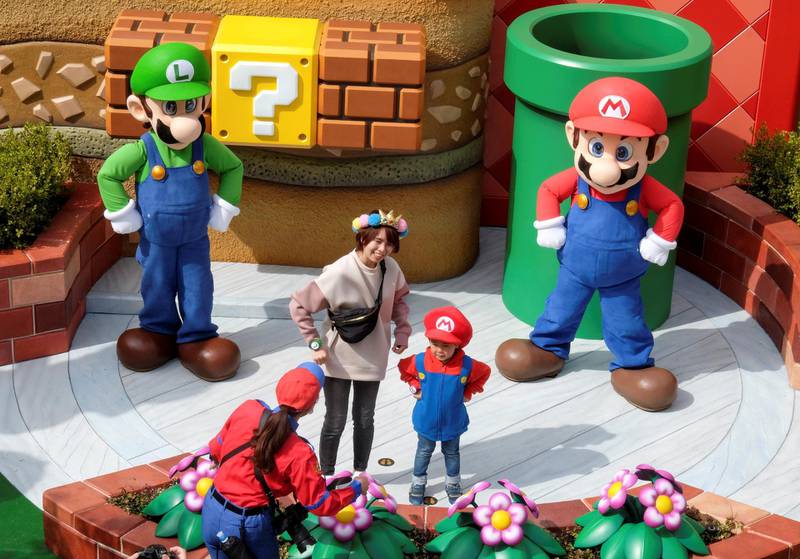 Mario and Luigi characters greet visitors in front of Yoshi's Adventure attraction. Reuters