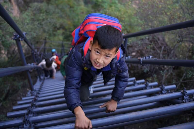 High achievers ... children in Liangshan Yi autonomous prefecture in Sichuan, China use a steel ladder on their way home from school. The ladder in November replaced the old vines the children previously scaled to reach Atuler village on the clifftop. More than 20 pupils from the school use the ladder as a safer and shorter way home up the 800m cliff at Meigu River Canyon. Getty Images