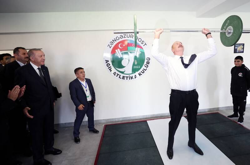Azerbaijan's President Ilham Aliyev lifts weights as Turkey's President Tayyip Erdogan looks on during their visit to a sports club near the city of Zangilan, recaptured by Azerbaijani forces from ethnic Armenians in 2020 during the military conflict in the breakaway region of Nagorno-Karabak. Reuters
