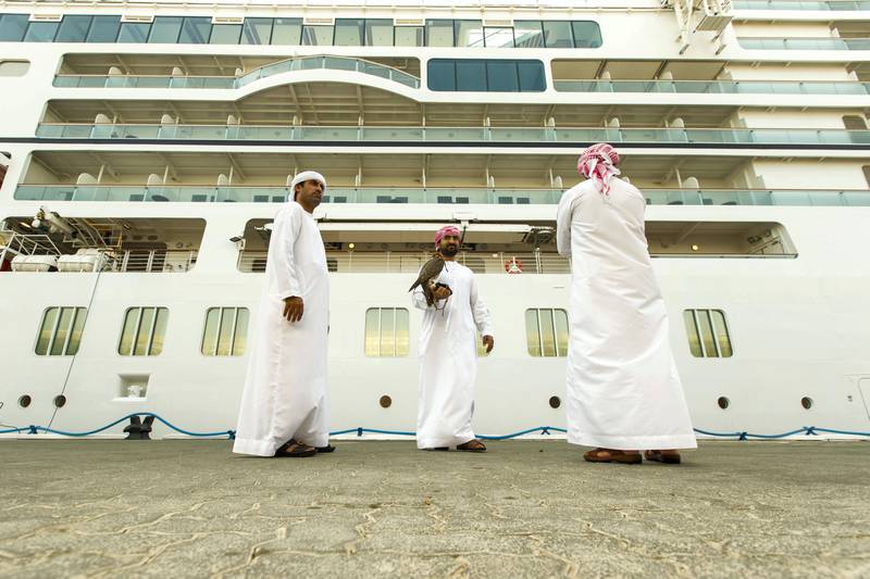 Abu Dhabi, United Arab Emirates, October 23, 2017:    Emirati men wait to greet passengers disembarking from the Seabourn Encore ship at the cruise terminal in the Mina Zayed area of Abu Dhabi on October 23, 2017. Christopher Pike / The National

Reporter: John Dennehy
Section: News