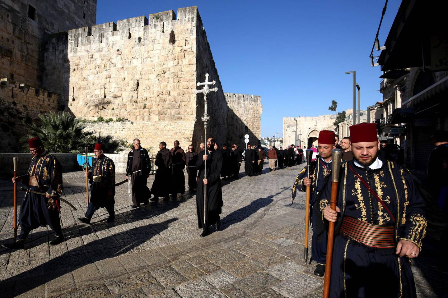 Kawases in traditional Ottoman outfits lead a procession of Roman Catholic clergymen on Holy Thursday (Maundy Thursday) outside the Church of the Holy Sepulchre in Jerusalem's Old City on April 18, 2019, traditionally believed to be the site of Christ's crucifixion and resurrection. / AFP / GALI TIBBON
