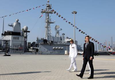 French president Emmanuel Macron walk alongside naval officers at a naval base in Abu Dhabi on November 9, 2017.  Ludovic Marin / AFP