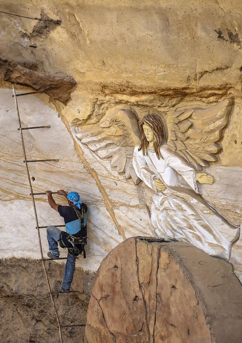 Polish artist Mario, sculptor of St. Simon the Tanner Monastery complex, climbs a ladder while working on a relief at the church in the Egyptian capital Cairo's eastern hillside Mokattam district. Mario spent more than two decades carving the rugged insides of the seven cave churches and chapels of the rock-hewn St. Simon Monastery and church complex atop Cairo's Mokattam hills, with designs inspired by biblical stories. It was all done to fulfil the wishes of the church's parish priest who met Mario in the early 1990s in Cairo. The Polish artist, who had arrived in Egypt earlier on an educational mission, was then looking for an opportunity to serve God at the monastery. AFP