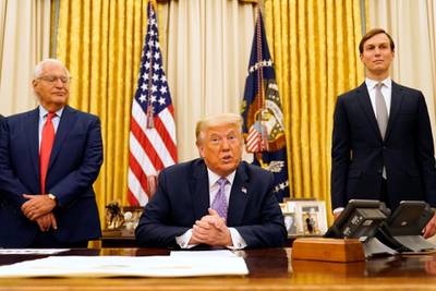 President Donald Trump speaks in the Oval Office at the White House, Thursday, Aug. 13, 2020, in Washington. White House senior adviser Jared Kushner is at right. (AP Photo/Andrew Harnik)