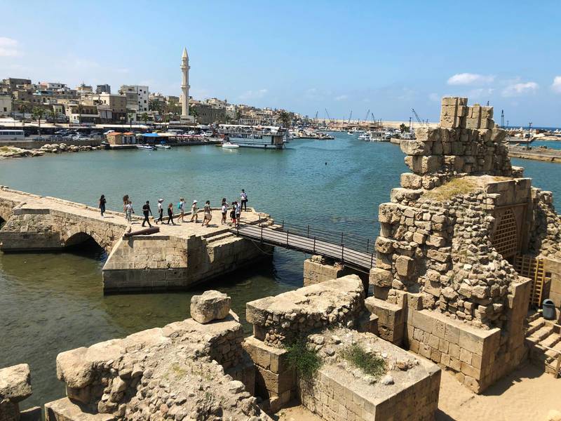 Tourists walk together at the sea castle in the Lebanese port city of Sidon.