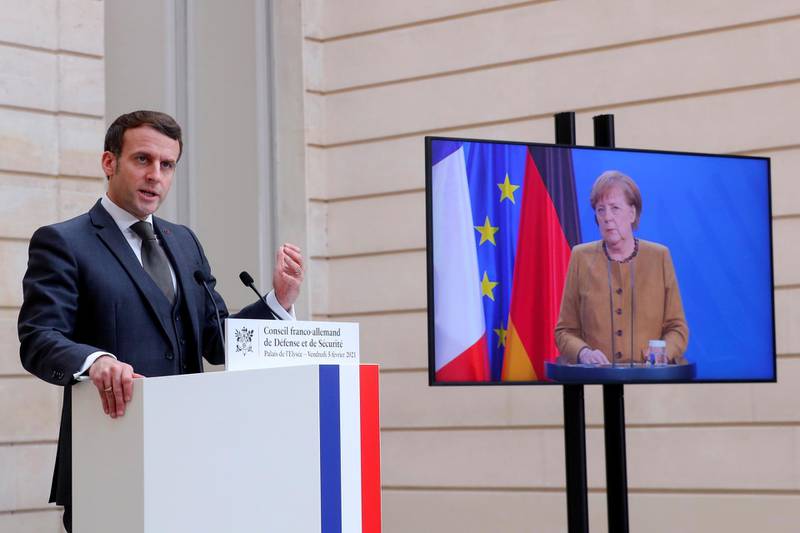 French President Emmanuel Macron speaks as German Chancellor Angela Merkel looks on after a German-French Security Council video conference at the Elysee Palace in Paris, France February 5, 2021.   Thibault Camus/Pool via REUTERS