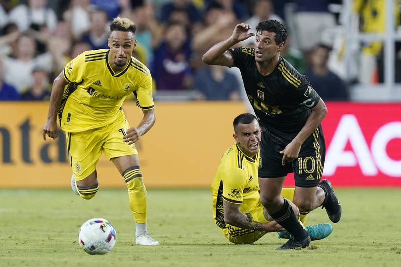 Nashville SC's Hany Mukhtar, left, and LAFC's Carlos Vela, right, run for the ball. AP