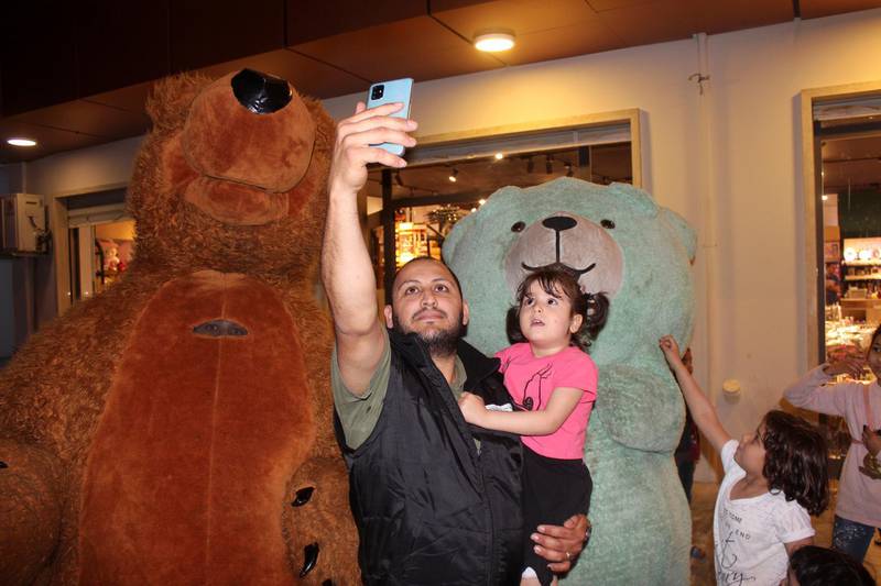 A man takes a selfie with his daughter next to persons wearing bear costumes, in preparation for Eid Al Fitr, marking the end of Ramadan, following the outbreak of the coronavirus disease, in Misrata, Libya. REUTERS