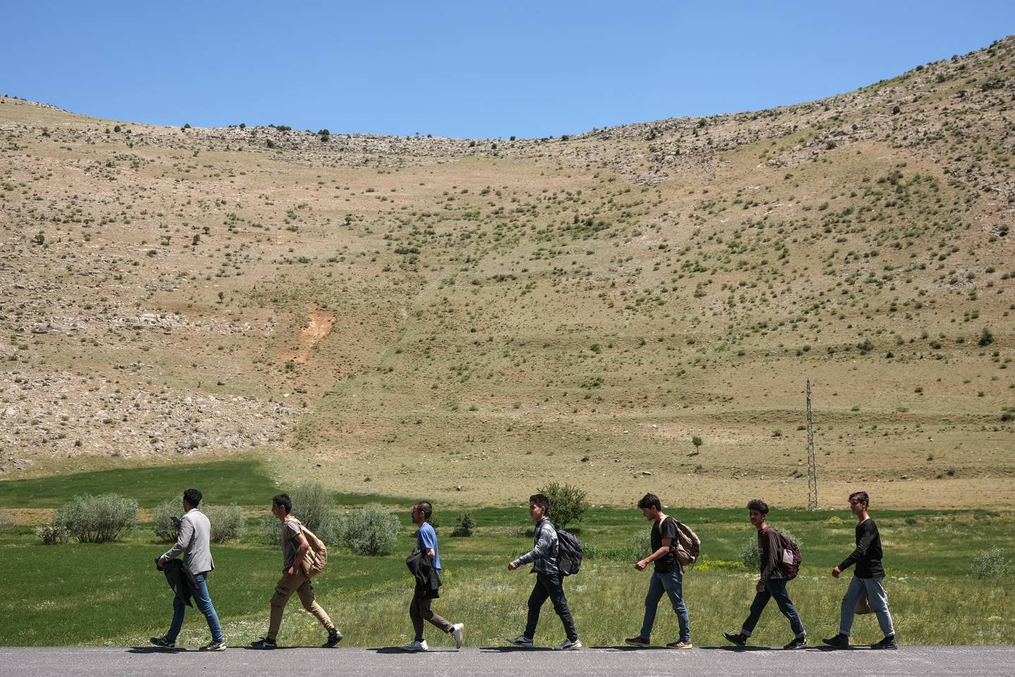 Ahmed, third from right, from Afghanistan and his friends on a road near Van city after crossing the Iran-Turkey border. EPA