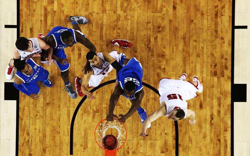 Alex Poythress of Kentucky dunks as Sam Dekker of Wisconsin defends during Saturday’s Final Four game. Jamie Squire / Getty Images / AFP / April 5, 2014