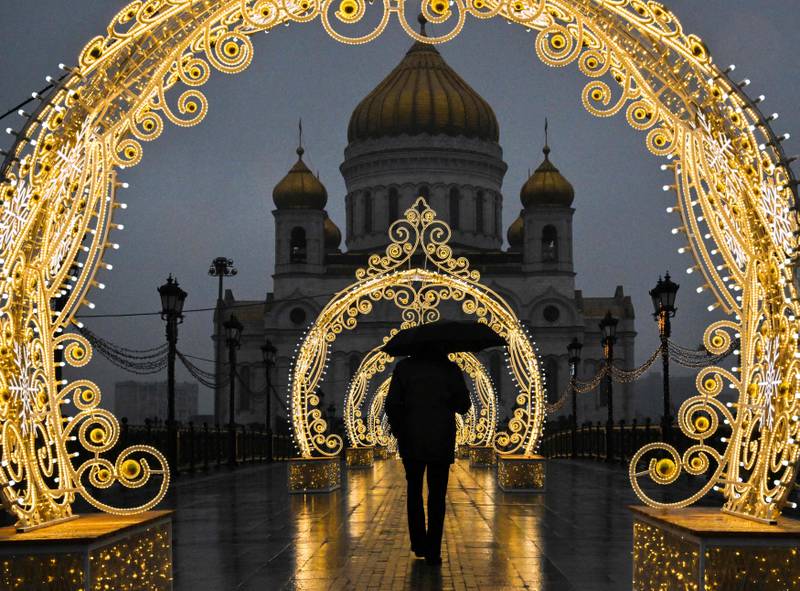 A pedestrian walks past Christmas decorations near the Cathedral of Christ the Saviour in central Moscow. AFP