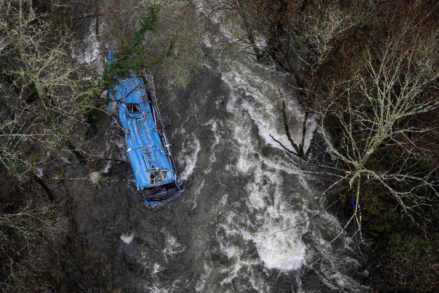 The wreck of a bus lies in the Lerez river after it plunged off a bridge on December 24 night near Vigo and the border with Portugal. The bus was carrying people visiting their loved ones jailed in Monterroso in central Galicia. AFP