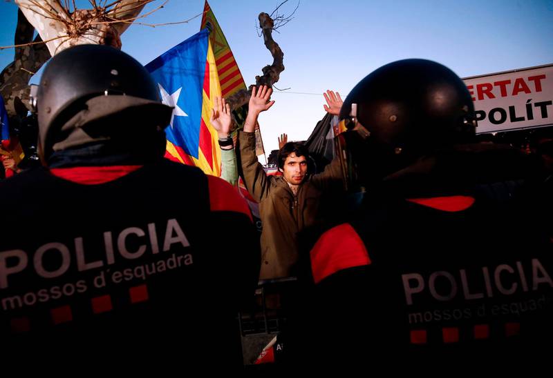 Demonstrators raise their hands as they stand in front of 'Mossos D'Esquadra' officers (Catalan regional police) during a demonstration outside the Catalan parliament on January 30, 2018 in Barcelona.
The speaker of Catalonia's parliament Roger Torrent delayed a key debate in the regional assembly on ousted separatist leader Carles Puigdemont's bid to form a new government, but defended his right to return to power. / AFP PHOTO / Pau Barrena