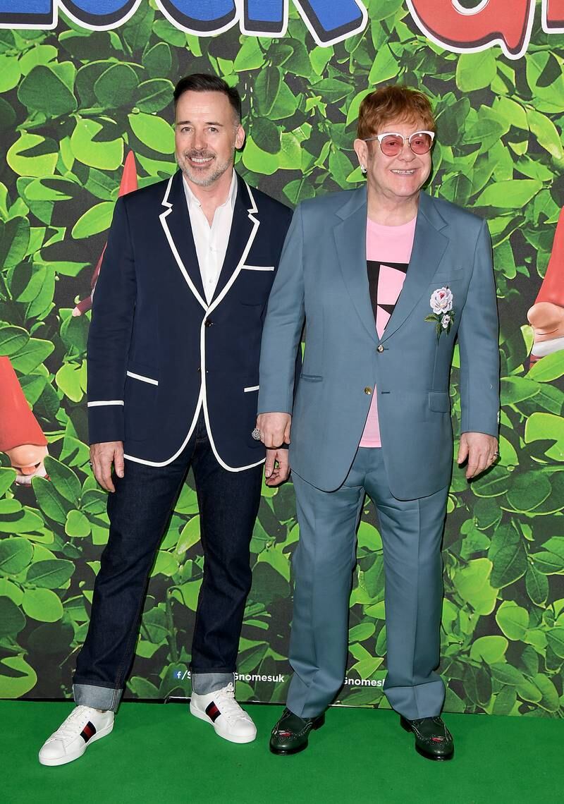 David Furnish and Elton John, in a grey suit with a pink T-shirt, attend the 'Sherlock Gnomes' family gala  at Cineworld Leicester Square, London on April 22, 2018. Getty Images