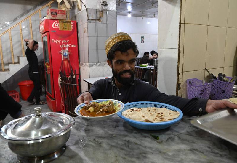 Rozi Khan prepares to serve food to customers at Dilbar Hotel in Rawalpindi. AFP