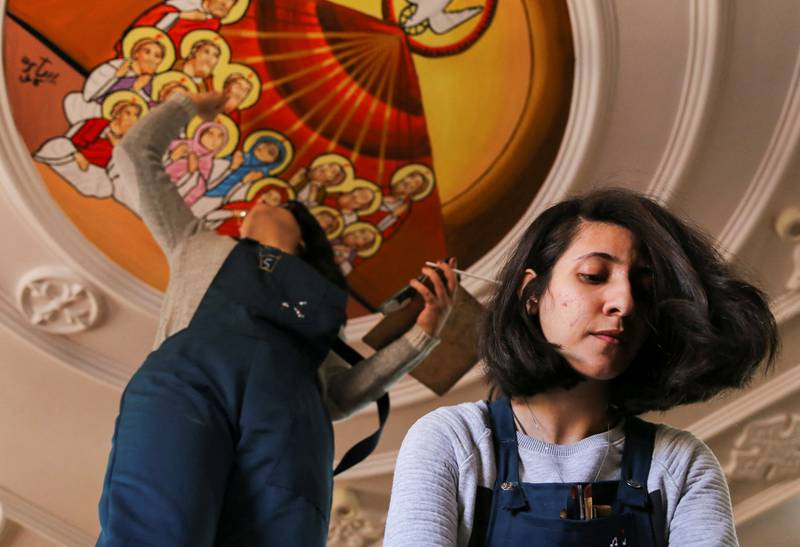 Sara Kamel Zekry and her sister Christine work on a mural in southern Egypt. All photos: Reuters