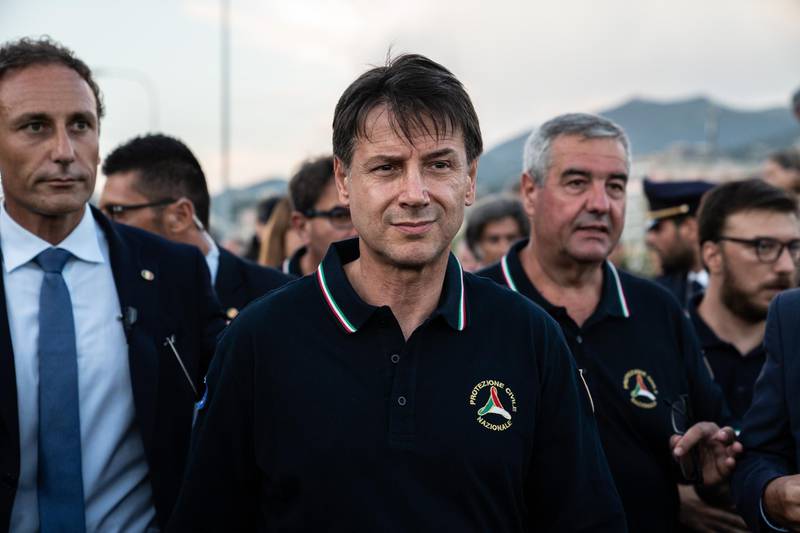 Giuseppe Conte, Italy's prime minister, center, arrives at the site of the collapsed Morandi motorway bridge in Genoa, Italy, on Tuesday, Aug. 14, 2018. The bridge on the main highway running down the Italian Mediterranean coast in the port city collapsed, and reports said at least 20 people died with others trapped in the rubble. Photographer: Federico Bernini/Bloomberg