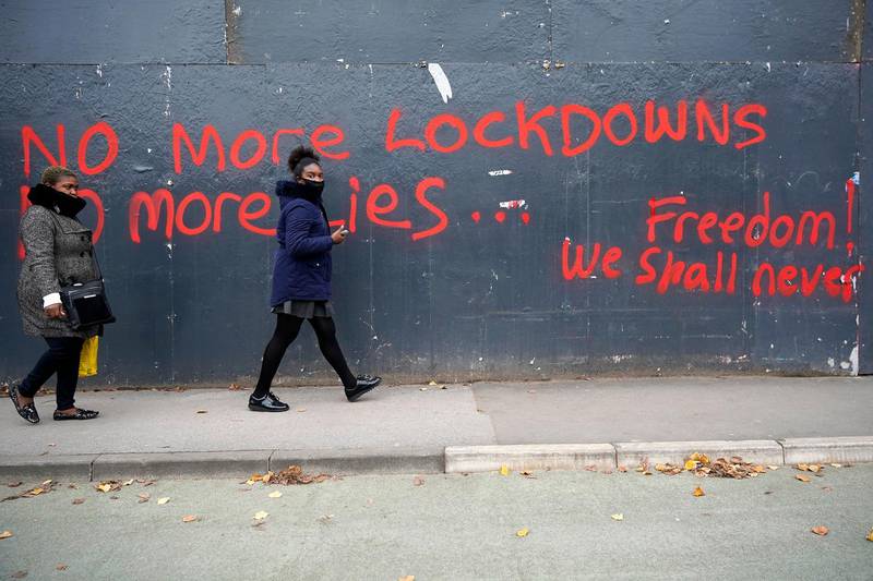 People walk past anti-lockdown graffiti in Manchester. Getty Images