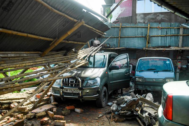A man checks cars in a garage damaged by cyclone Amphan in Satkhira.  AFP