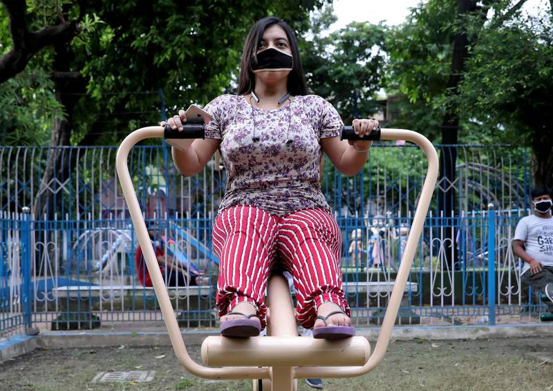 A woman wearing a protective face mask exercises at an open-air gym in a municipal park amidst the coronavirus disease (COVID-19) outbreak in Kolkata, India, September 21, 2020. REUTERS/Rupak De Chowdhuri