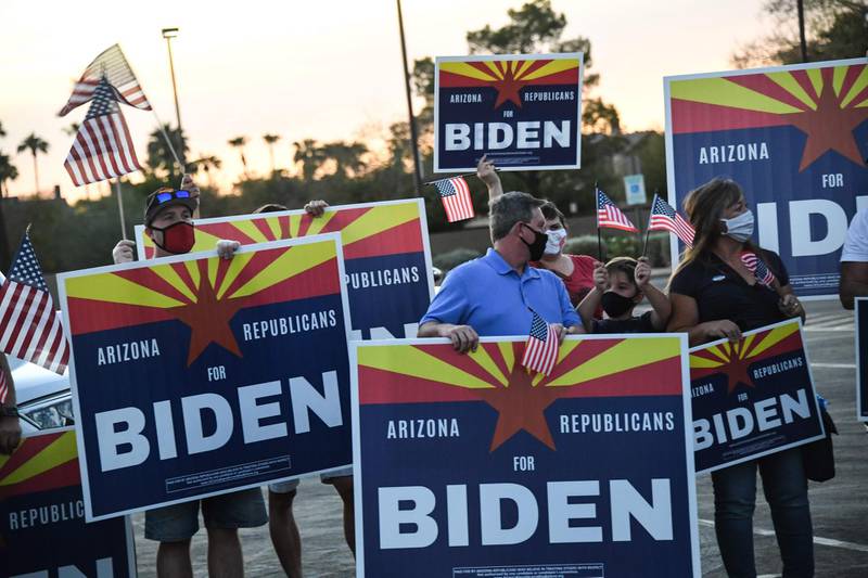 Members of the group "Arizona Republicans Who Believe In Treating Others With Respect" hold signs in support of Democratic presidential candidate Joe Biden, during evening rush hour in Phoenix, Arizona. AFP