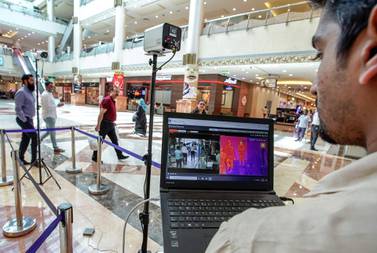 A technician operates a newly-installed thermal scanner at Khalidiyah Mall in Abu Dhabi. Victor Besa / The National