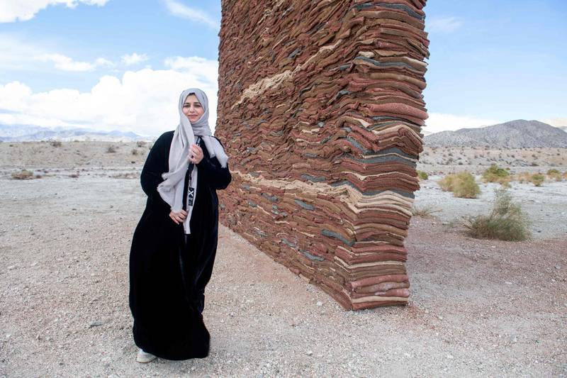Saudi Arabian artist Zahrah Al Ghamdi poses in front of her piece, 'What Lies Behind the Walls', during the media preview day of the Desert X exhibit, in the Coachella Valley near Desert Hot Springs, California. AFP