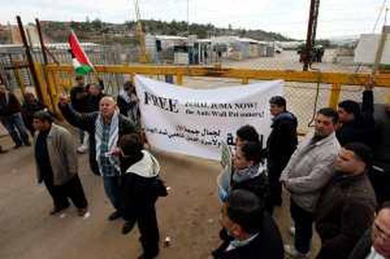 epa01979601 Palestinian relatives of Jamal Juma, one of the leaders of the Palestinian public campaign against the Israeli sepeartion barrier, and activists take part in a protest to demand his release, at the Bitwnia Checkpoint leading to the Israeli Military prison of Ofer near the West Bank town of Ramallah, 04 January 2010.  EPA/ATEF SAFADI