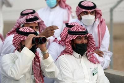 A member of the Moon-sighting committee looks through binoculars, near Riyadh, Saudi Arabia. Reuters