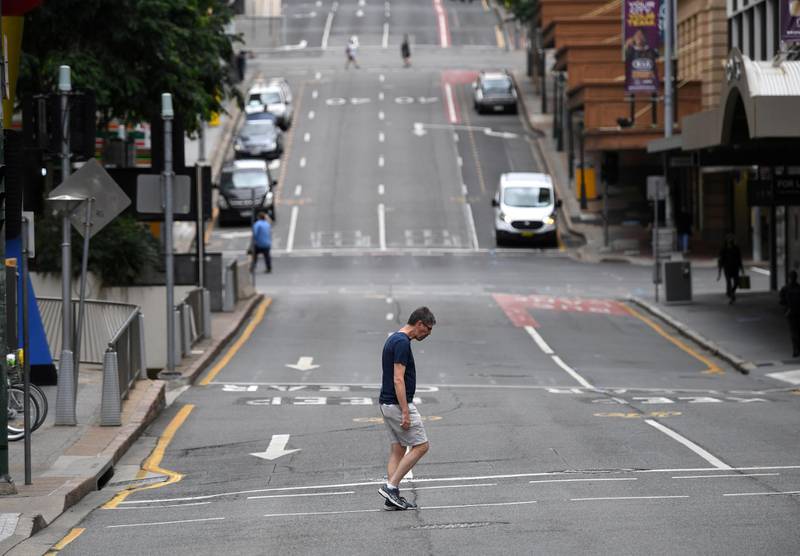 A man crosses a mostly empty city centre street as people in Greater Brisbane have been ordered into lockdown as authorities try to suppress a growing coronavirus disease cluster in Brisbane, Australia. Reuters