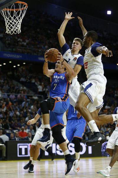 Oklahoma City Thunder forward Ersan Ilyasova, left, jumps to the basket against Real Madrid. Daniel Ochoa de Olza / AP