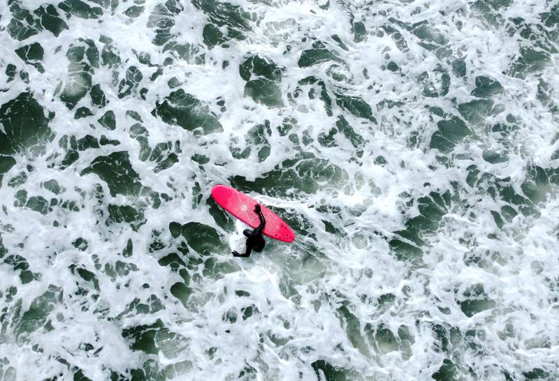 The UK enjoyed warm weather on Tuesday and this surfer makes the most of the favourable conditions in the sea off Tynemouth beach on the north-east coast. PA