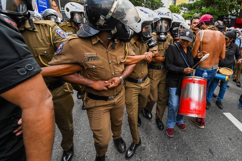 Policemen try to block Sri Lankan university students from gathering. AFP