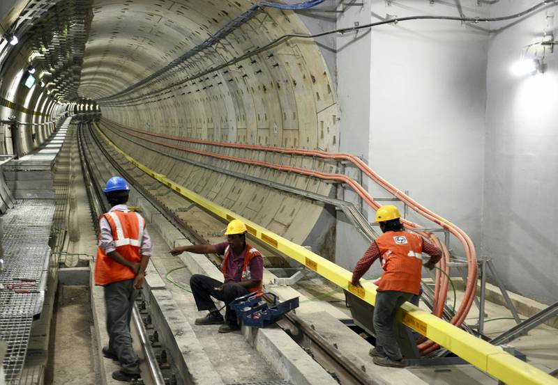 Indian employees of the Namma Metro Rail carry out inspection work near a tunnel that will connect two major parts of Bangalore on April 26, 2016. 
Namma Metro are scheduled to inaugurate south India's first 4.8km underground line, with the first commercial run taking place on April 30. / AFP PHOTO / Manjunath Kiran