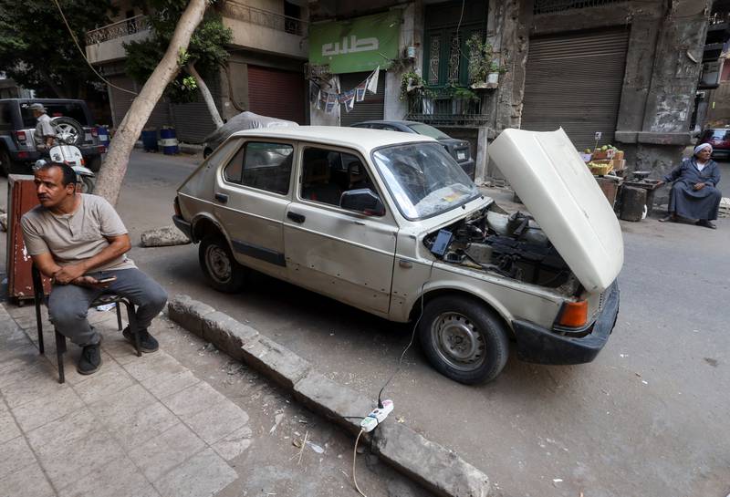 Mr Al Saeed sits as his car charges in Cairo. He said there was a marked difference in cost between electric and petrol-powered cars.