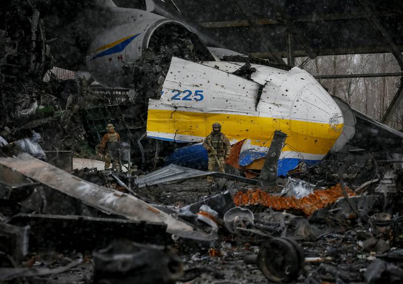 A Ukrainian soldier walks in front of the remains of an Antonov An-225 Mriya cargo plane, the world's biggest aircraft, destroyed by Russian troops at an airfield in the city of Hostomel, in the Kyiv region. Reuters