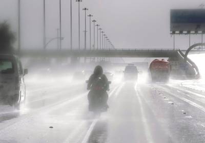 Abu Dhabi, United Arab Emirates, March 21, 2020.  A motorbike rider braves the slippery road on the Sheikh Zayed Bin Sultan Street during rainshowers.    Victor Besa / The National