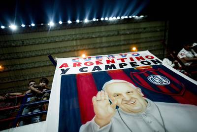 A banner with an image of Pope Francis and a message that reads in Spanish: “Cuervo, Argentine and Champion,” during a national football league match between San Lorenzo and Colon de Santa Fe in Buenos Aires, Argentina, Natacha Pisarenko / AP Photo / March 15, 2014. 