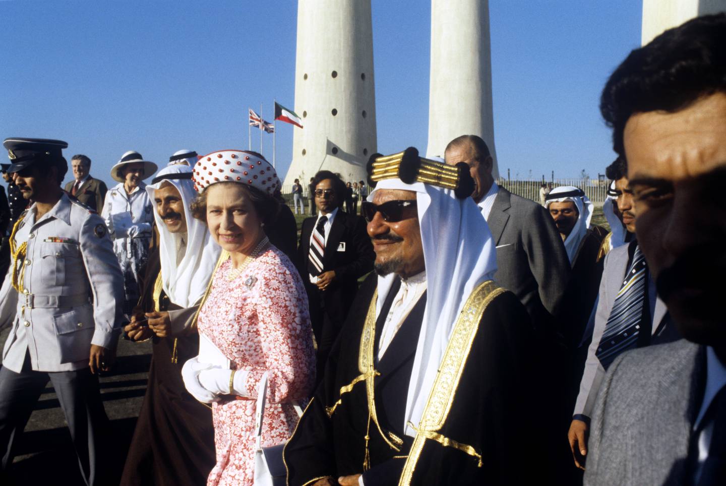 Queen Elizabeth, accompanied by Arab dignitaries, attends a folk dance display in the shadow of Kuwait's water towers. PA Images via Getty Images
