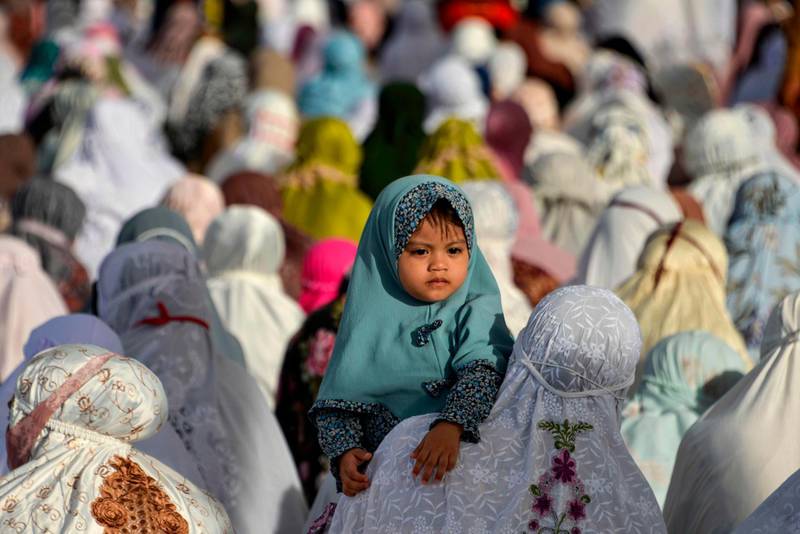 A child looks as Indonesians Muslims attend an Eid Al Adha prayer at the Baiturrahman grand mosque in Banda Aceh. AFP