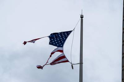 A torn US national flag is seen during Hurricane Sally landfall in Mobile, Alabama. AFP