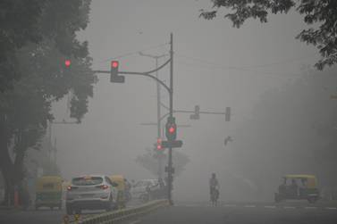 Motorists drive along a road under heavy smog conditions, in New Delhi on Sunday. AFP
