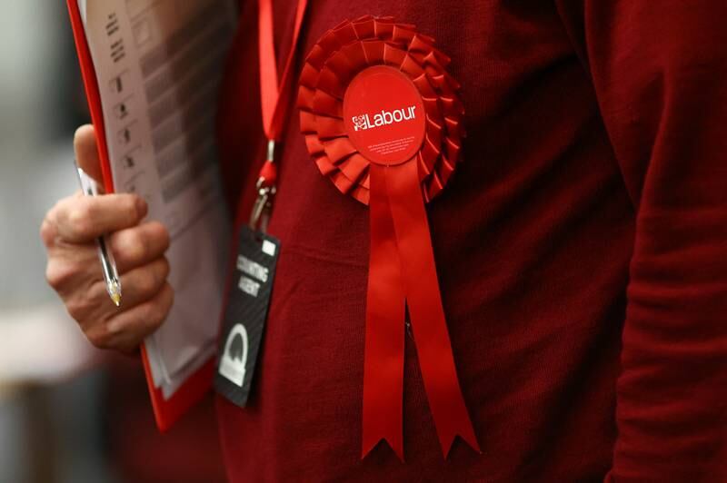 An election monitor wears a Labour Party rosette at Wandsworth Town Hall in London. Reuters