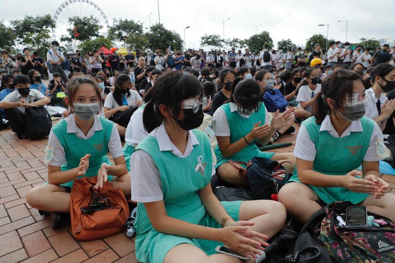 Secondary school pupils sit on the ground during a protest. AP