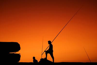 epaselect epa06212530 Palestinians are silhouetted as they fish during sunset in the west Gaza City, 17 September 2017 (issued 18 September 2017).  EPA/MOHAMMED SABER